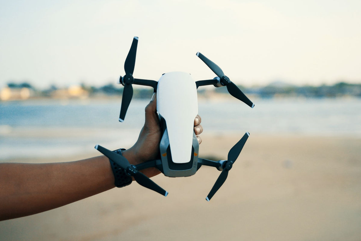 Angler checking a drone safety app on the beach before a CASA-compliant fishing-drone flight