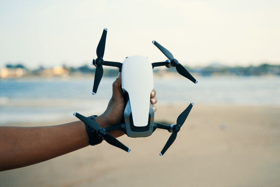 Angler checking a drone safety app on the beach before a CASA-compliant fishing-drone flight