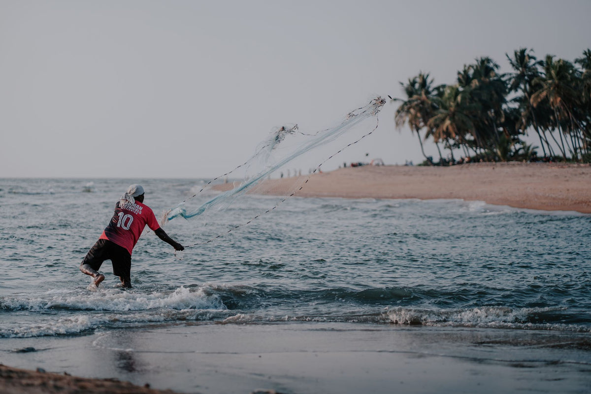 Angler on an Australian beach watching a fishing drone fly out over the ocean, illustrating how visual line of sight limits legal flying distance